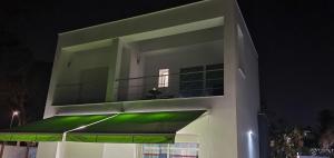 - un bâtiment blanc avec un balcon vert la nuit dans l'établissement Villa Cristal, à Chiclana de la Frontera