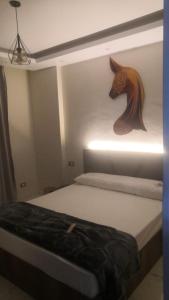 ein Schlafzimmer mit einem Bett mit einem Pferdekopf an der Wand in der Unterkunft Ismailia in ‘Ezbet Abd el-Hâdi ‘Afîfi