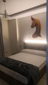 een slaapkamer met een bed met een paardenkop aan de muur bij Ismailia in ‘Ezbet Abd el-Hâdi ‘Afîfi