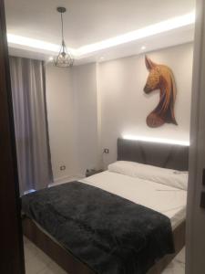 1 dormitorio con 1 cama con cabezal de caballo en la pared en Ismailia en ‘Ezbet Abd el-Hâdi ‘Afîfi