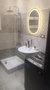 ein Badezimmer mit einem Waschbecken, einer Badewanne und einem Spiegel in der Unterkunft Ismailia in ‘Ezbet Abd el-Hâdi ‘Afîfi