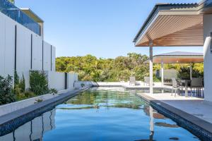 een zwembad in de achtertuin van een huis bij Oceanus oasis at Bokarina Beach -stunning modern coastal apartment in Kawana Waters