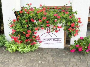 a sign for a bunny park with red flowers at Harmony Park 