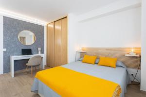 a bedroom with a yellow bed and a desk at EUROSOL LOFT in Torremolinos