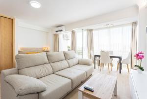 a white living room with a couch and a table at EUROSOL LOFT in Torremolinos