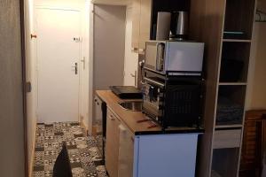 una piccola cucina con forno a microonde e lavandino di Mes vacances à la montagne a Villarembert 1 altra foto
