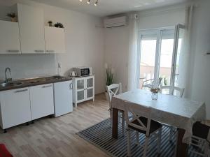 a kitchen with a table and a table and chairs at Villa Marin in Pag