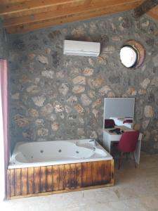 een bad in een kamer met een stenen muur bij Fethiye Havuzlu Villa in Fethiye
