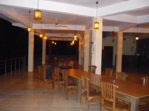 ein Esszimmer mit einem großen Holztisch und Stühlen in der Unterkunft Red Letter Hotel in Kandy