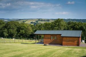 a small wooden cabin in a field of grass at Pastures Green Cabin (Oak Tree Lane) in Okehampton
