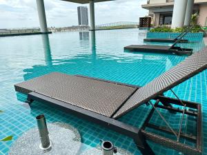 a swimming pool with a bench in the water at Bali Residence Melaka near Jonker Street in Melaka