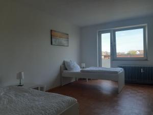 ein weißes Zimmer mit einem Bett und einem Fenster in der Unterkunft Apartment mit Balkon in Lünen in Lünen