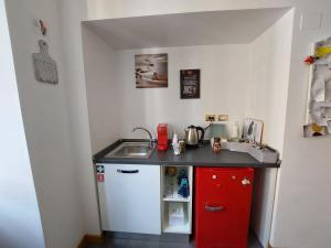 a small kitchen with a sink and a red cabinet at B&B Gaudium Colosseo in Rome
