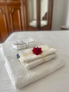 una pila de toallas con una rosa sobre una mesa en Vico Gioia, en Roccasicura