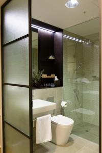 a bathroom with a toilet and a glass shower at Coppersmith Hotel in Melbourne