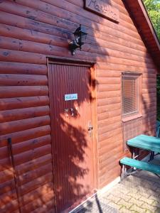 una puerta a una cabaña de madera con una mesa de picnic en Apartmánová chata Martina, en Hradišťko