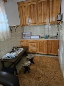 uma pequena cozinha com armários de madeira e uma mesa em Sarajevo Samanta apartment em Sarajevo