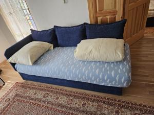 Un sofá azul con dos almohadas. en Sarajevo Samanta apartment, en Sarajevo