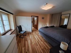 a bedroom with a bed and a desk and a chair at Schloss Hilbringen Gesindewohnungen in Merzig +7 photos