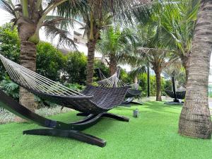 two hammocks in a park with palm trees at Bali Residence Melaka near Jonker Street in Melaka