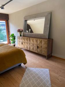 1 dormitorio con cama y espejo en la pared en Megina Lodge, en Mayen