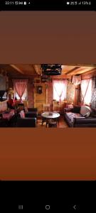 uma sala de estar com sofás, uma mesa e janelas em PrenocisteMelinaSjenica em Sjenica