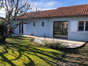 una casa blanca con un árbol y un patio en Villa Moderne + Guest House + Piscine chauffée, en Gujan-Mestras