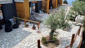 a patio with trees and a table and chairs at Rahoni Park & Suites in Dhërmi