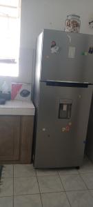 a refrigerator sitting in a kitchen next to a counter at White house in Flic-en-Flac +7 photos