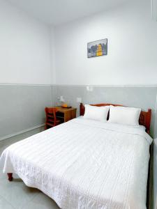 a bedroom with a white bed and a table at Thanh Ngoc Motel 2 in Buon Ma Thuot