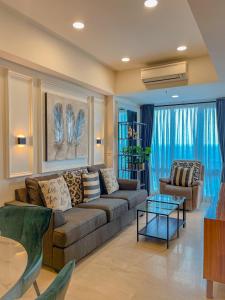 sala de estar con sofá y mesa en Brand new 2BR Empire Tower - Podomoro City, en Medan