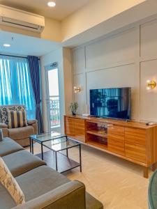 sala de estar con sofá y TV en Brand new 2BR Empire Tower - Podomoro City, en Medan