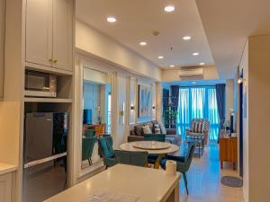 uma sala de estar com um sofá e uma mesa em Brand new 2BR Empire Tower - Podomoro City em Medan
