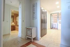 a room with a hallway with a refrigerator and a bathroom at Apartamento en residencial de lujo Los Flamengos in Estepona