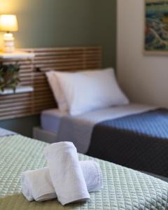 two towels on two beds in a hotel room at Vivid Stays Petralona in Athens