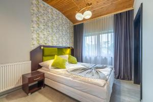 a bedroom with a large bed with yellow pillows at Apartamenty Amber in Rewal