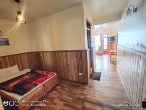 a bedroom with a bed and a wooden floor at Hotel Hidden House (Fair View) in Pelling