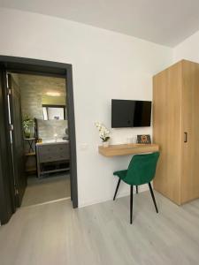 a room with a desk and a green chair at Vila Moga in Sînmartin