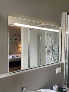 a mirror over a sink in a bathroom at Cucchiari Suite 8B in Modena
