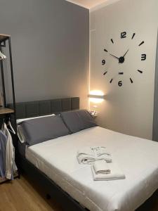 a bedroom with a clock on the wall and a bed at Cucchiari Suite 8B in Modena