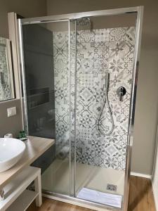 a shower with a glass door next to a sink at Cucchiari Suite 8B in Modena