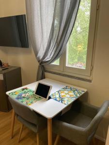 a table with a laptop on it next to a window at Cucchiari Suite 8B in Modena