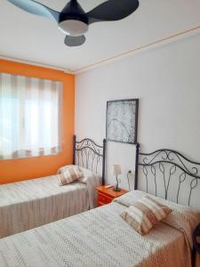 a bedroom with two beds and a ceiling fan at Chalet luminoso in L’Alfàs del Pi