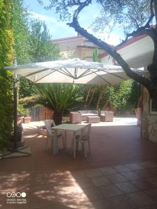 - une table et des chaises sous un parasol sur la terrasse dans l'établissement Relax a Marco Simone -Casa Domitilla -, à Marco Simone