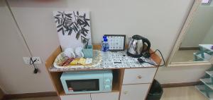 a small table with a microwave on a counter at La Suite@Alanis Residence in Sepang