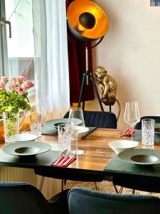 einen Holztisch mit Tellern und Weingläsern darauf in der Unterkunft Premium Wohnung in Bestlage! in München