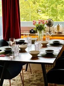 einen Tisch mit Schalen und Gläsern und eine Vase Blumen in der Unterkunft Premium Wohnung in Bestlage! in München