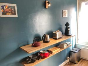 a kitchen with wooden shelves with pots and pans at La plage in Fécamp