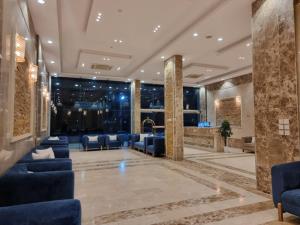 a lobby with blue chairs and a waiting room at الديار الفاخرة للشقق المخدومة in Al Qunfudhah