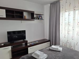 een slaapkamer met een tv en een bed met handdoeken bij FARMEC Apartament in Cluj-Napoca